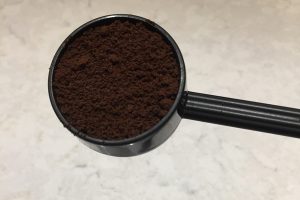 An AeroPress scoop filled with coffee