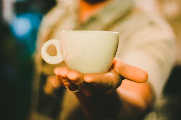 Coffee mug on an extrended hand