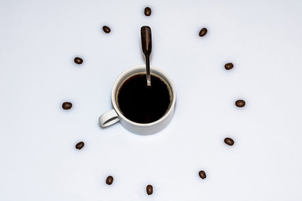 a clock made from a mug for the center and coffee scoops as the hands