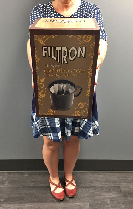 a woman presenting a Filtron Toddy/ cold-brew brewer box