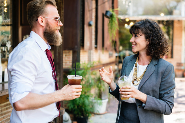 a man and woman drinking cold-brew outside