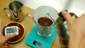 hot water is poured from a kettle into a Clever-Dripper that sits on a kitchen scale