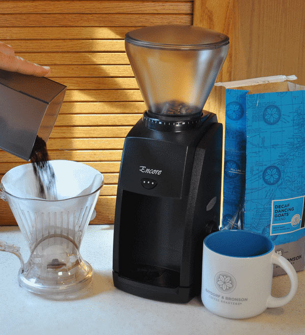 How to Choose a Coffee Grinder - A photo depicting a coffee grinder, mug, and ground coffee in a kitchen.