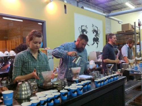 four Batdorf employees brewing pourover coffee behind the bar