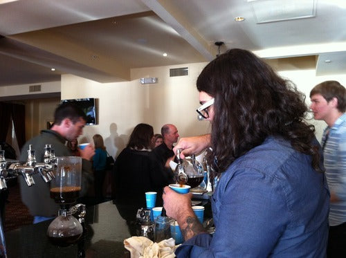 a barista presses an AeroPress